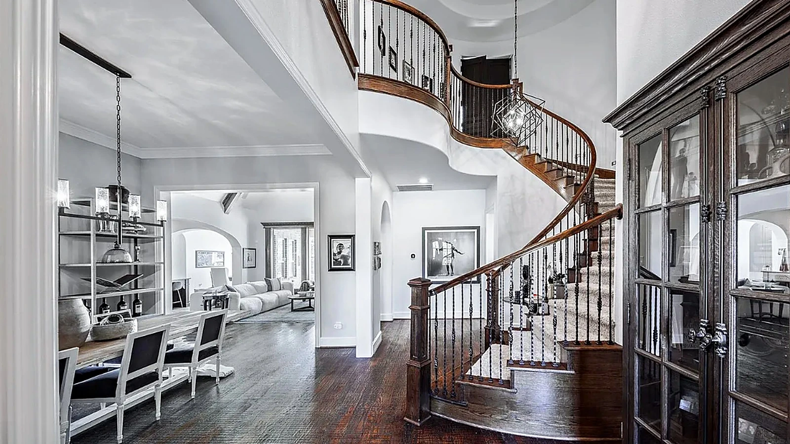 Two-story foyer with curved staircase and wrought-iron balusters in Bellaire home renovation by Bager Remodeling