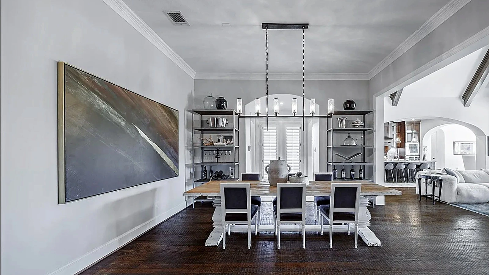 Curved wood and iron staircase in double-height entry hall of renovated Bellaire home Houston Texas
