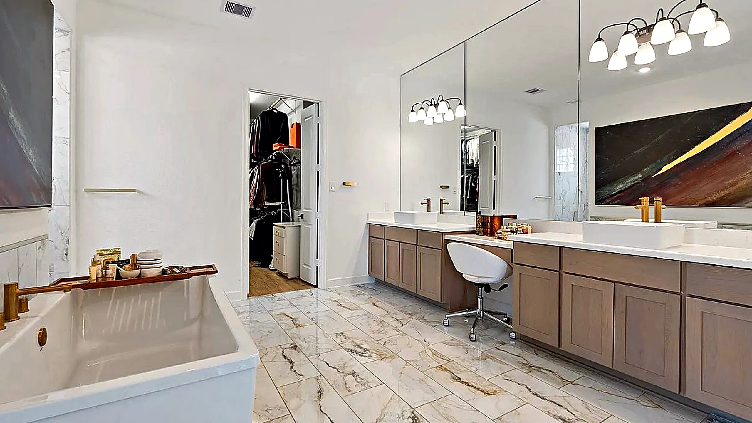 Double vanity with light wood cabinetry and vessel sinks reflecting the tub and stone tile — Woodlands bathroom renovation