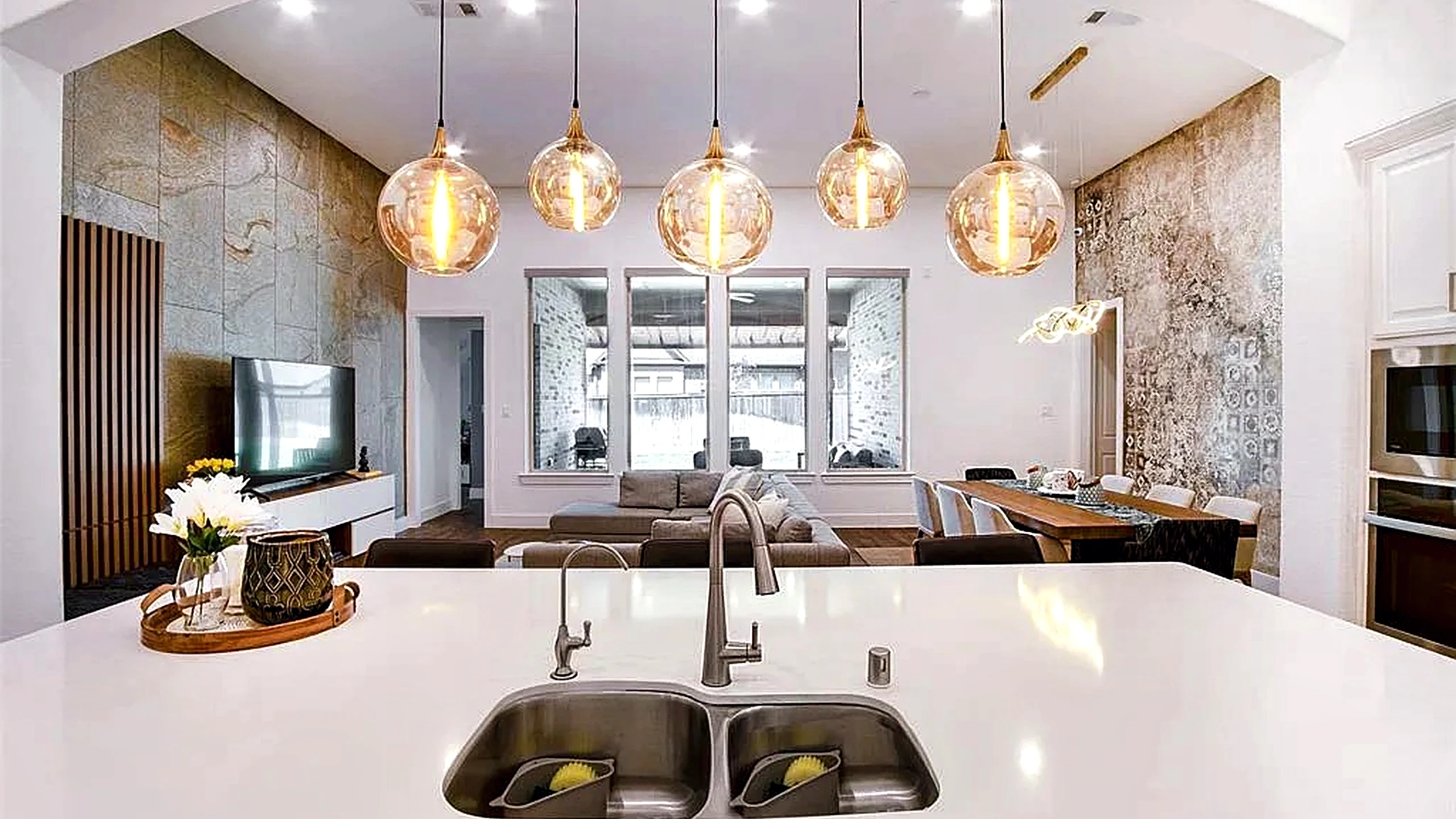 Cypress home kitchen and living room remodel with white cabinetry, wood-look flooring, and an arched passage between spaces.