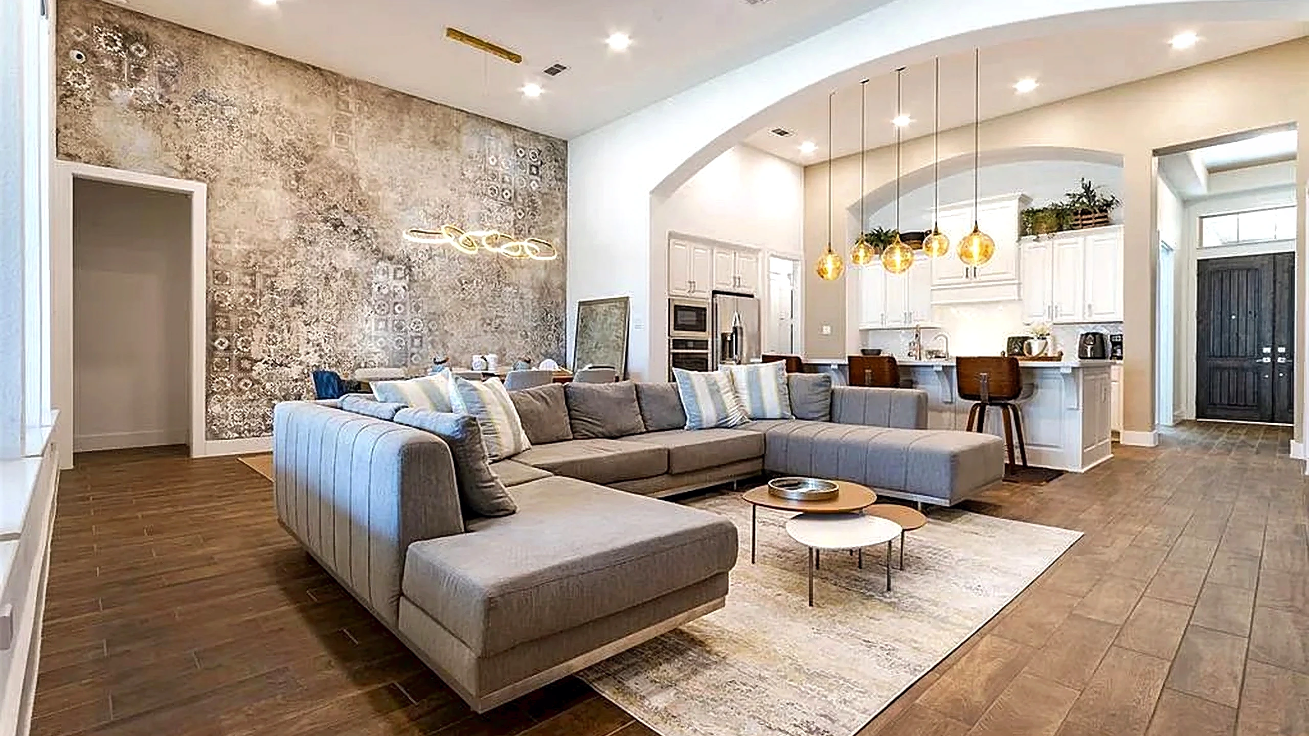 Cypress home remodel featuring white cabinetry, wood-look flooring, and an arched passage between the kitchen and living area