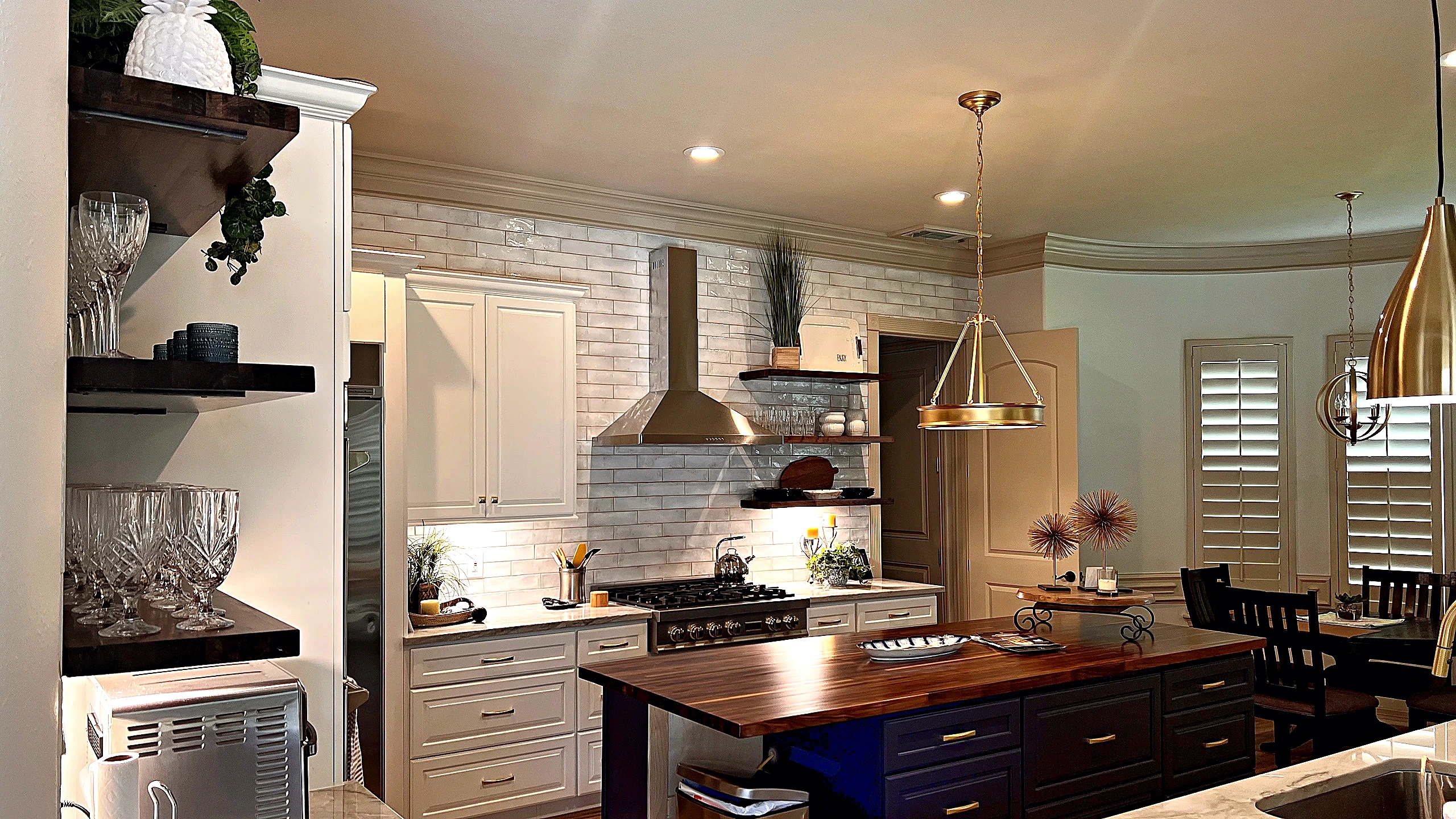 Brass drum pendant over kitchen island with glazed subway tile backsplash, Tomball Texas