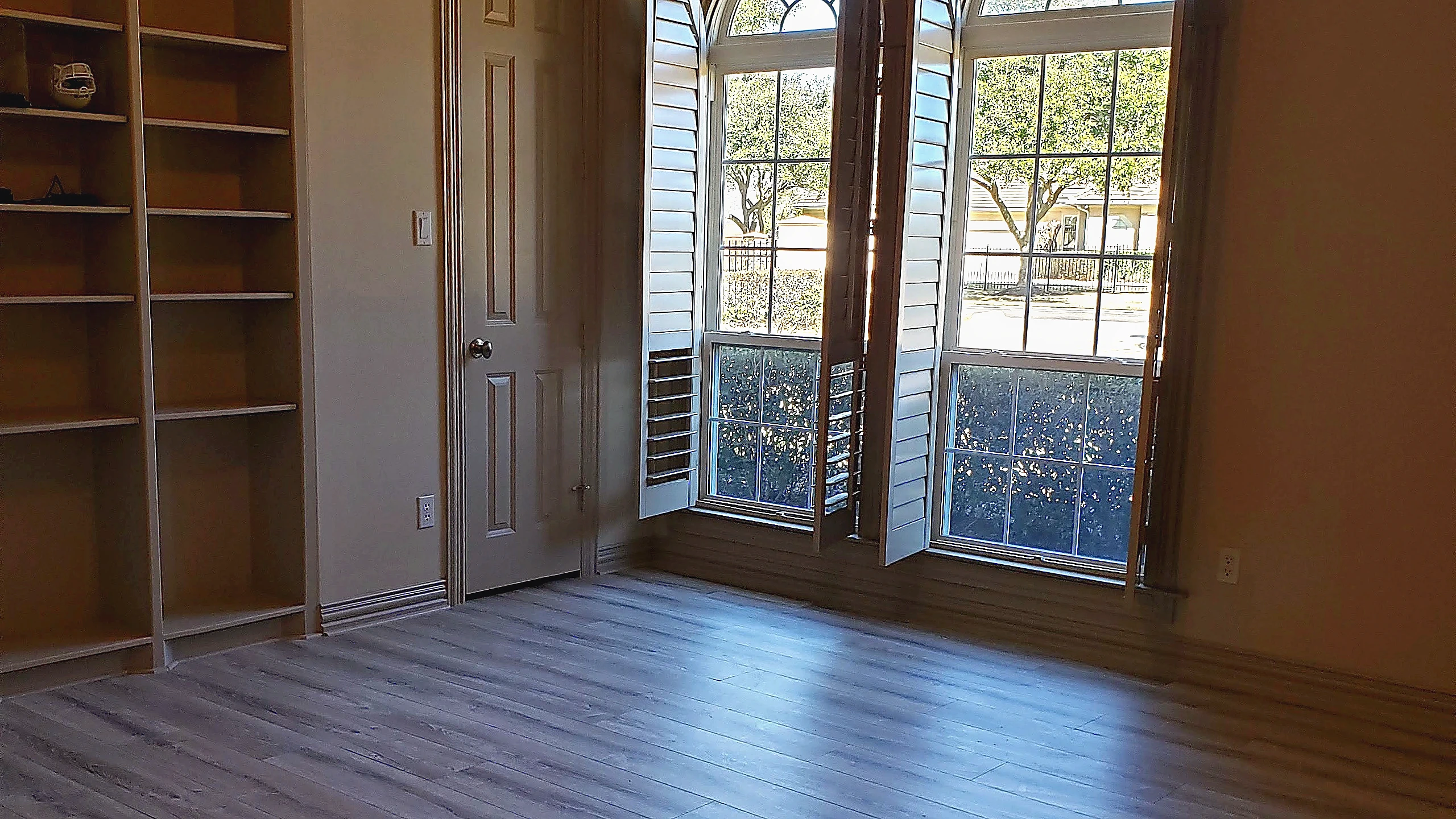 Dark-stained wood desk and upholstered nail-head armchair in the completed interior sitting room renovation